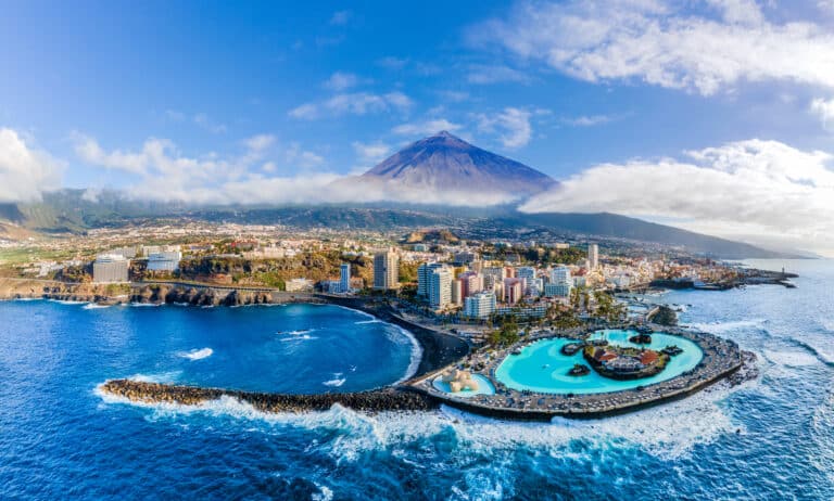 Letecký pohled na Puerto de la Cruz na Tenerife. V popředí je aquapark Lago martíanez, hora Teide je zobrazená v pozadí.